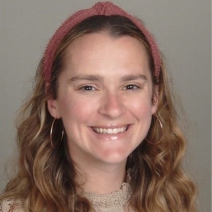 Woman with long wavy hair, pink headband, hoop earrings, and lace top smiles at the camera. She's at Always Reddy Nutrition in Pittsburgh, PA, owned by dietitian Allison Reddy. in Pennsylvania
