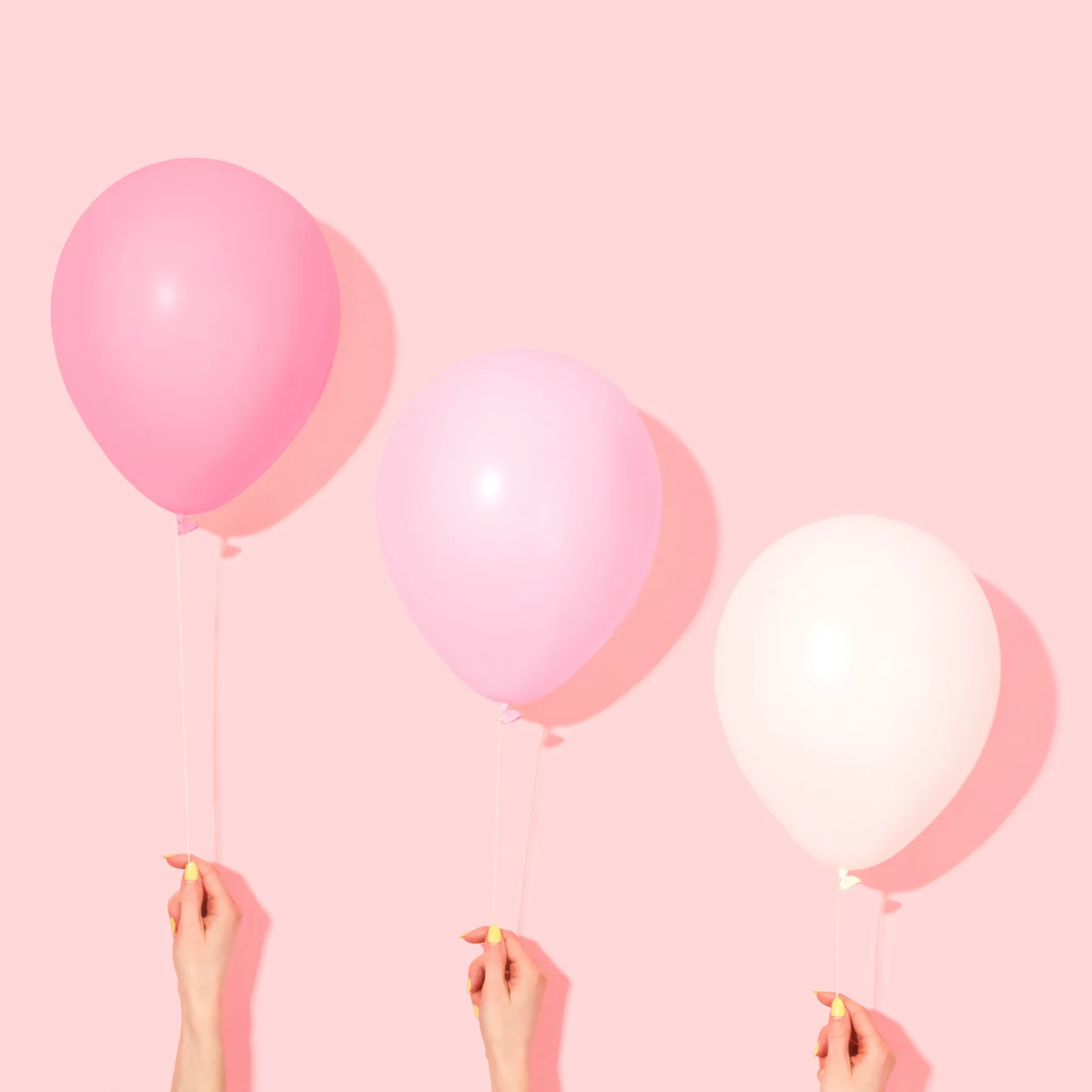 Three hands hold pink, light pink, and white balloons against a solid pink background, celebrating Always Reddy Nutrition in Pittsburgh, PA—owned by dietitian Allison Reddy, offering specialized nutrition care. in Pennsylvania
